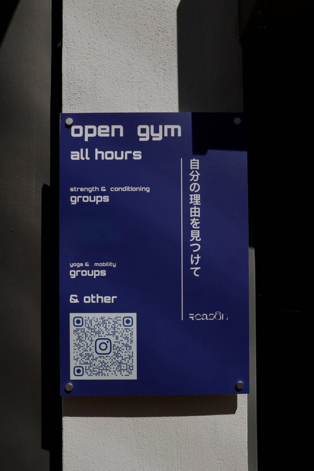 The blue Reason open gym poster on the wall: open gym, all hours, strength and conditioning groups